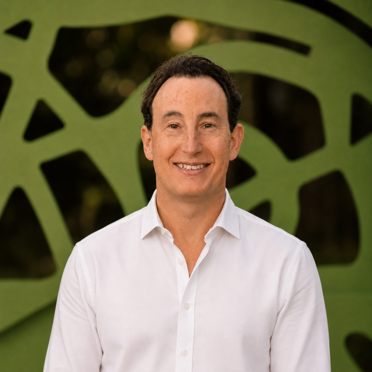Joel Schauermann, MD, Chief Medical Officer, smiling in a white shirt